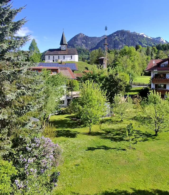 Garten des Haus Himmelsgleiter Allgäu in Sonthofen mit Blick auf den Grünten und die Kapelle St.Leonhard. Von der Kapelle aus hat man einen wundervollen Blick in die gesamte Oberallgäuer Alpenkette 